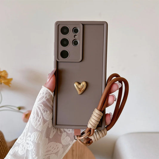 3D Gold Heart Wrist Strap Phone Case for Samsung Galaxy S25, TPU Protective Cover with Anti-Slip and Scratch-Resistant Design